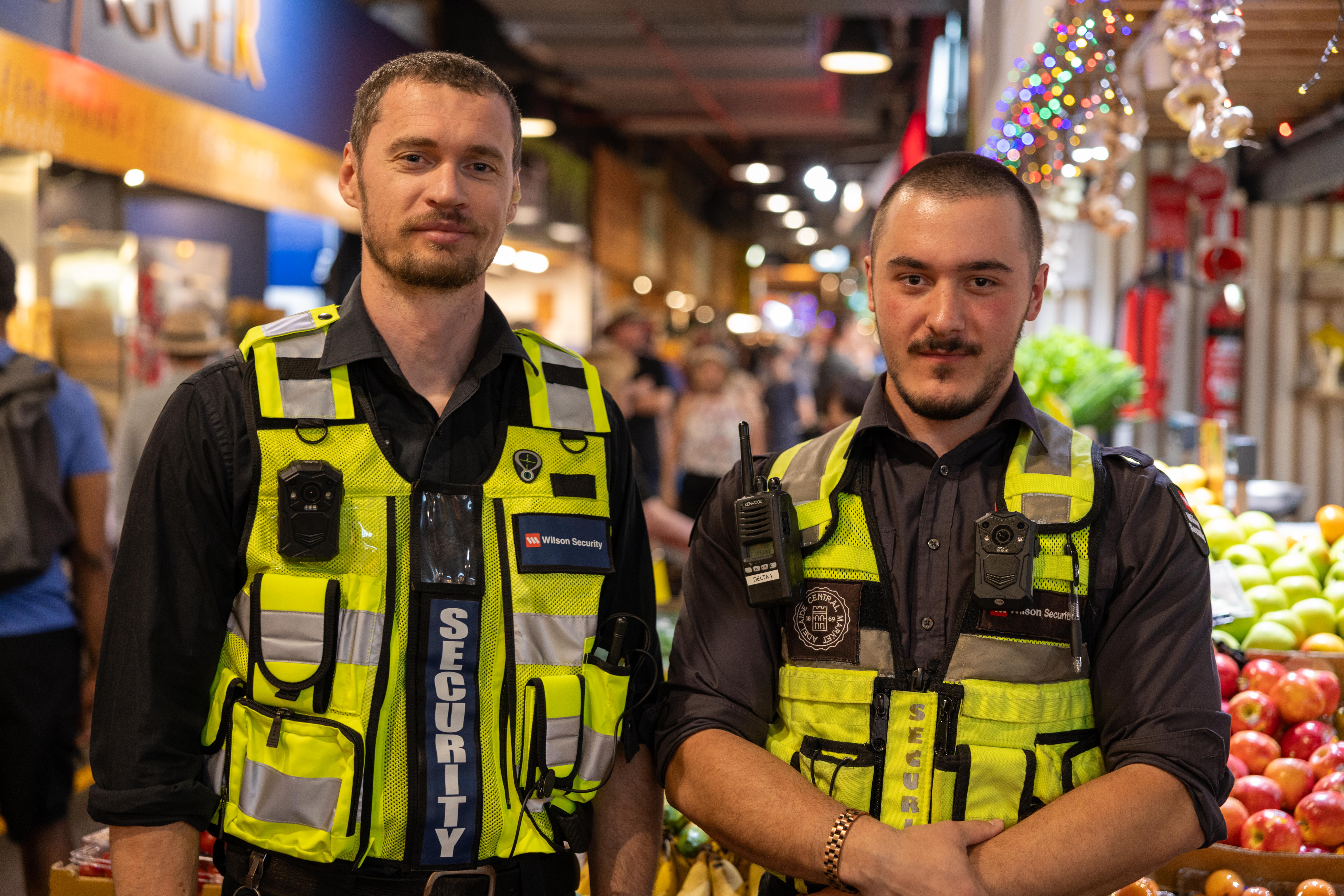 Two security guards at a market with body worn cameras